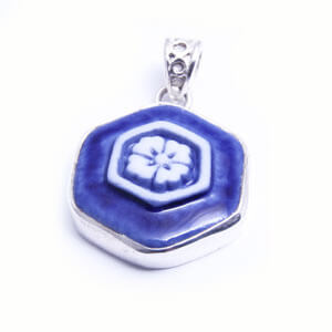 Hana is a hand carved hexagonal porcelain pendant glazed and set in sterling silver. Available in light blue, red, blue and grey.