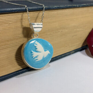 turquoise porcelain cameo set in silver with a book background