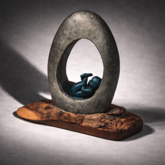 black clay sculpture of a baby in a womb with a wood base