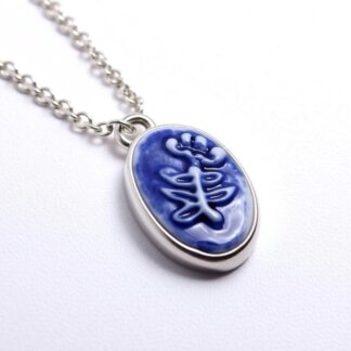 porcelain and silver cameo charm in a silver necklace