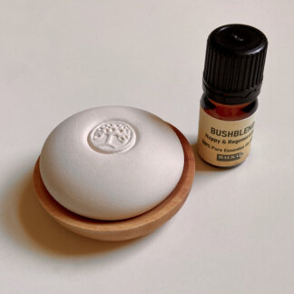 scent pebble with tree design in the center in a wood dish and EO bottle