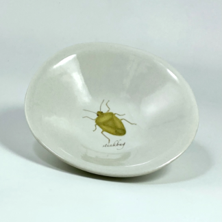 porcelain little bowl with a print of a green stinkbug in the center